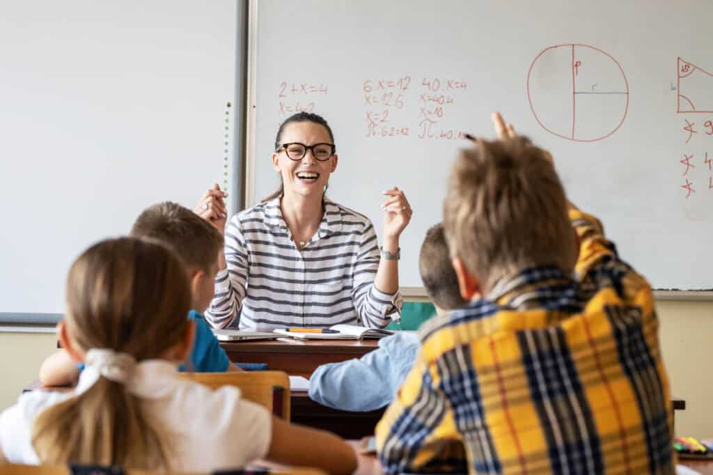 Professeur enseignant des mathématiques à une classe d'élèves en salle de classe.